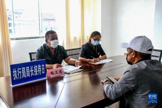 执行局局长接待日，鲍卫忠（左）在云南省沧源佤族自治县人民法院执行指挥中心接待案件当事人（2020年6月18日摄）。新华社发